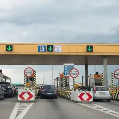 Korki na autostradzie przy bramkach poboru opłat. Samochody czekają w kolejce do przejazdu.