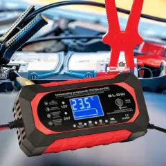 Prostownik samochodowy podłączony do akumulatora, wyświetlający 23.5°C.