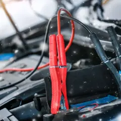 Kable rozruchowe podłączone do akumulatora w zimowy dzień. Czy żelowy akumulator można ładować zwykłym prostownikiem?