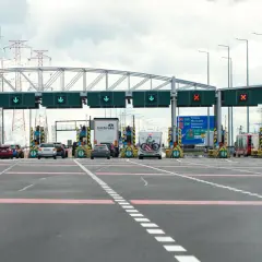 Bramki autostradowe, gdzie sprawdzisz, ile kosztuje autostrada do Zakopanego. W tle linie energetyczne.