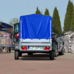 Ciężarówka z naczepą, przykryta niebieską plandeką, gotowa do transportu. Zastanawiasz się, ile waży ciężarówka z naczepą?