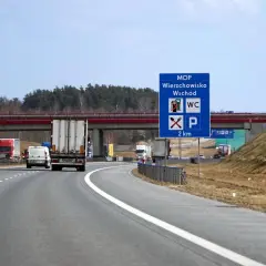 Znak MOP Wierzchowisko Wschód informuje o miejscu obsługi podróżnych z toaletą i parkingiem za 2 km.
