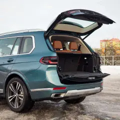 Zielony BMW X7 z otwartym bagażnikiem, gotowy na podróż. Sprawdź aktualną bmw x7 cena.