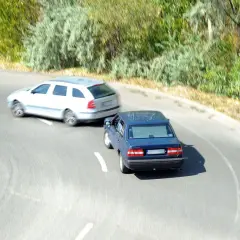 Niebieski sedan wyprzedza białe kombi, ignorując znak ustąp pierwszeństwa przejazdu art. 4.