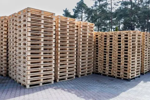 Stosy drewnianych palet czekają na załadunek. Zastanawiasz się, ile zmieści się palet na tirze?