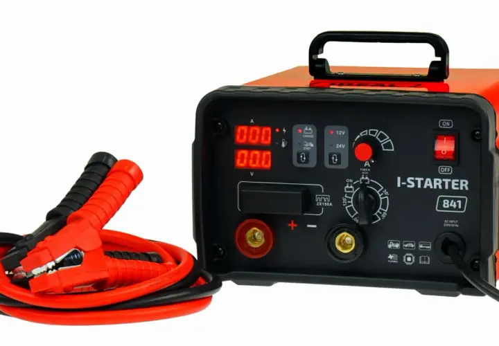 Pomarańczowy prostownik z kablami rozruchowymi. Zastanawiasz się, ile kosztuje dobry prostownik? Ten model I-STARTER 841 to solidny wybór.