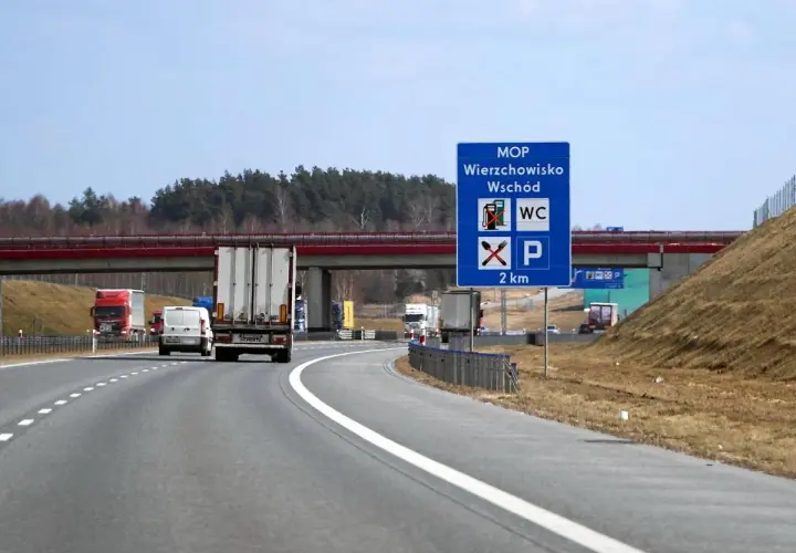 Znak MOP Wierzchowisko Wschód informuje o miejscu obsługi podróżnych z toaletą i parkingiem za 2 km.
