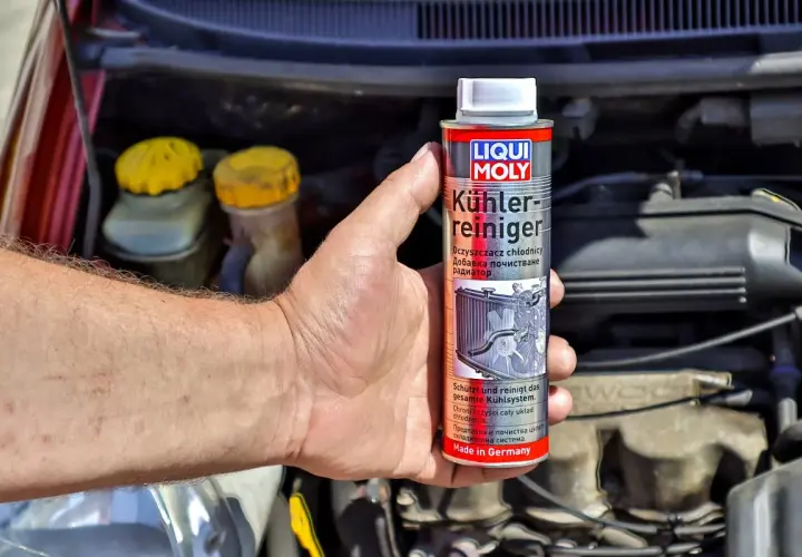 Ręka trzyma puszkę preparatu Liqui Moly do czyszczenia chłodnic. To klucz do tego, jak odkamienić chłodnicę.
