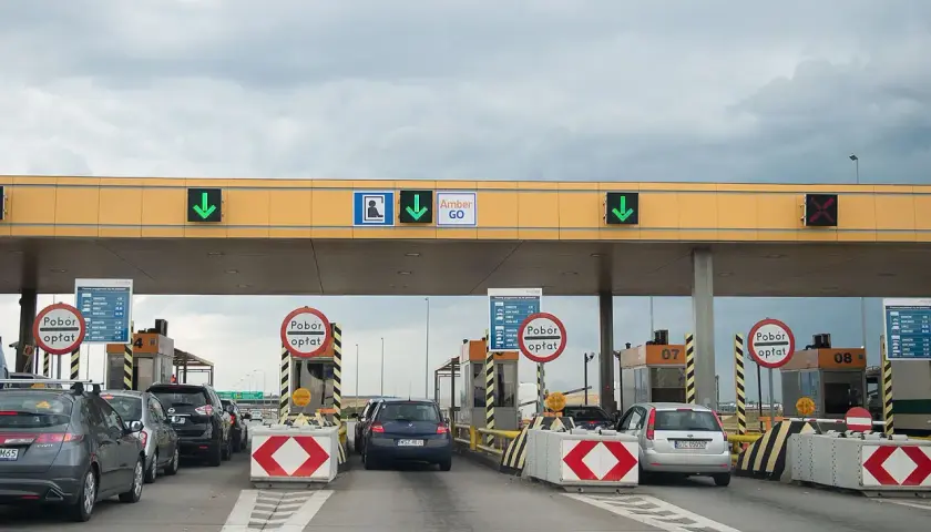Korki na autostradzie przy bramkach poboru opłat. Samochody czekają w kolejce do przejazdu.
