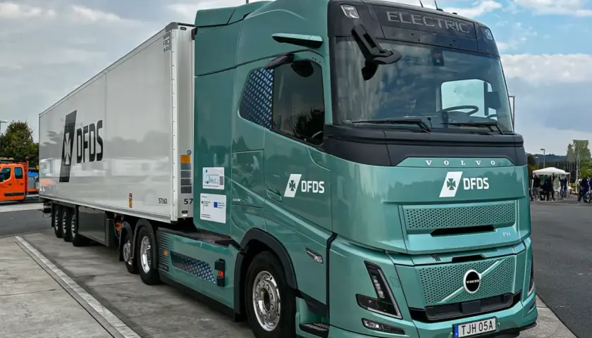 Zielony, elektryczny Volvo FH z naczepą DFDS. Zastanawiasz się, ile ton ma tir? Ten model jest gotowy na wyzwania.