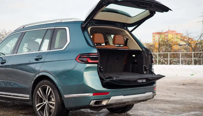 Zielony BMW X7 z otwartym bagażnikiem, gotowy na podróż. Sprawdź aktualną bmw x7 cena.