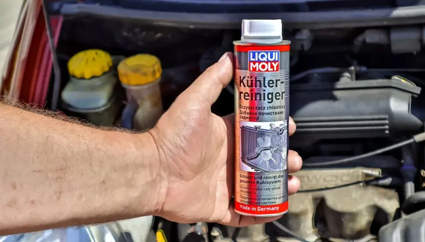 Ręka trzyma puszkę preparatu Liqui Moly do czyszczenia chłodnic. To klucz do tego, jak odkamienić chłodnicę.