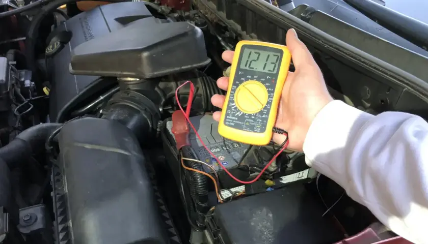 Pomiar napięcia multimetrem pokazuje 12.13V, co oznacza, że akumulator jest naładowany.