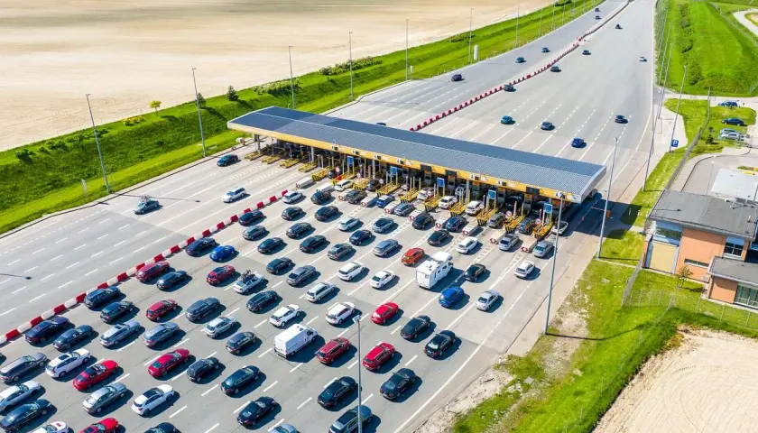 Korki na autostradzie. Czy na bramkach można płacić gotówką? Długi rząd samochodów czeka na przejazd przez punkt poboru opłat.