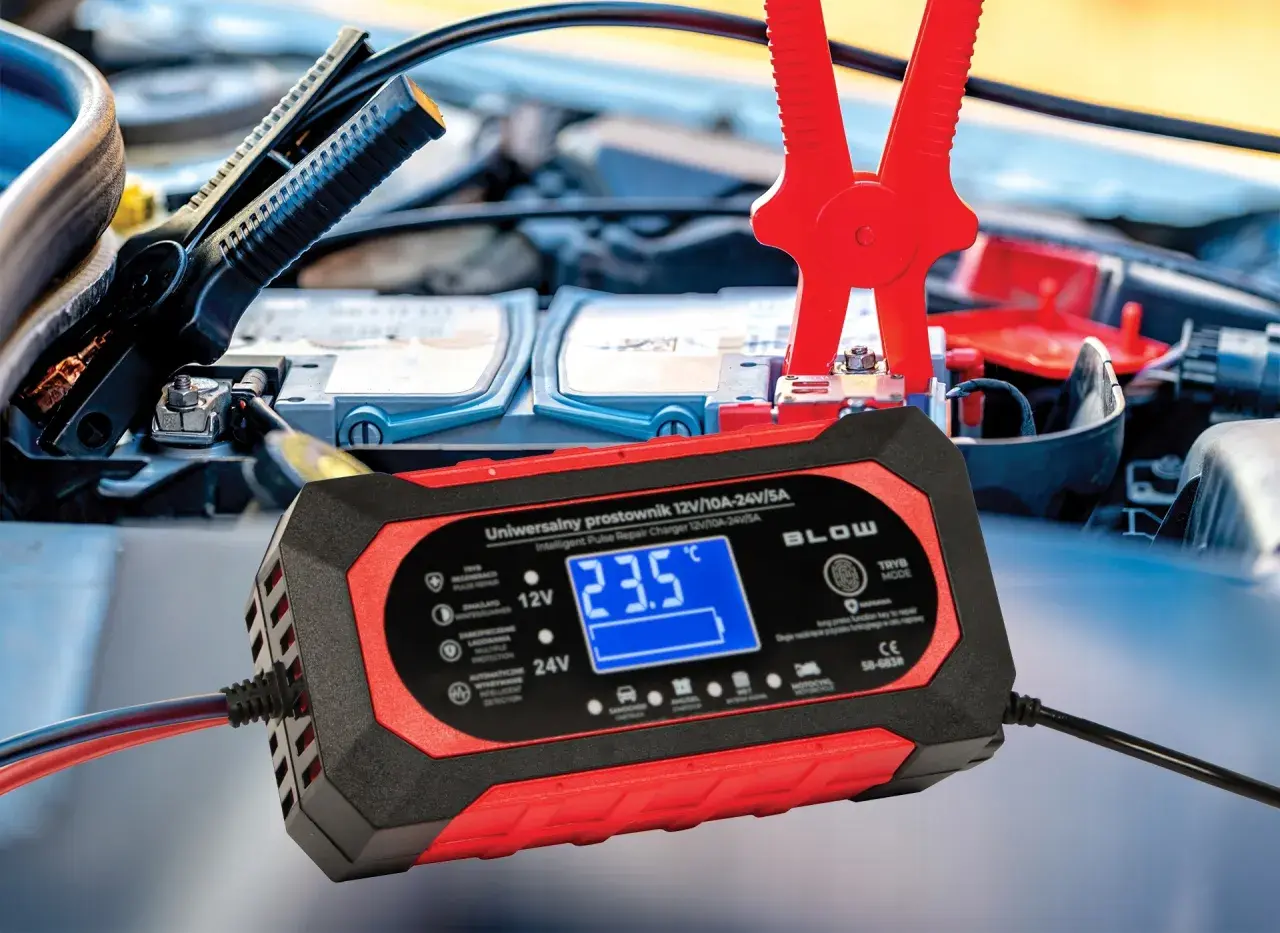 Prostownik samochodowy podłączony do akumulatora, wyświetlający 23.5°C.