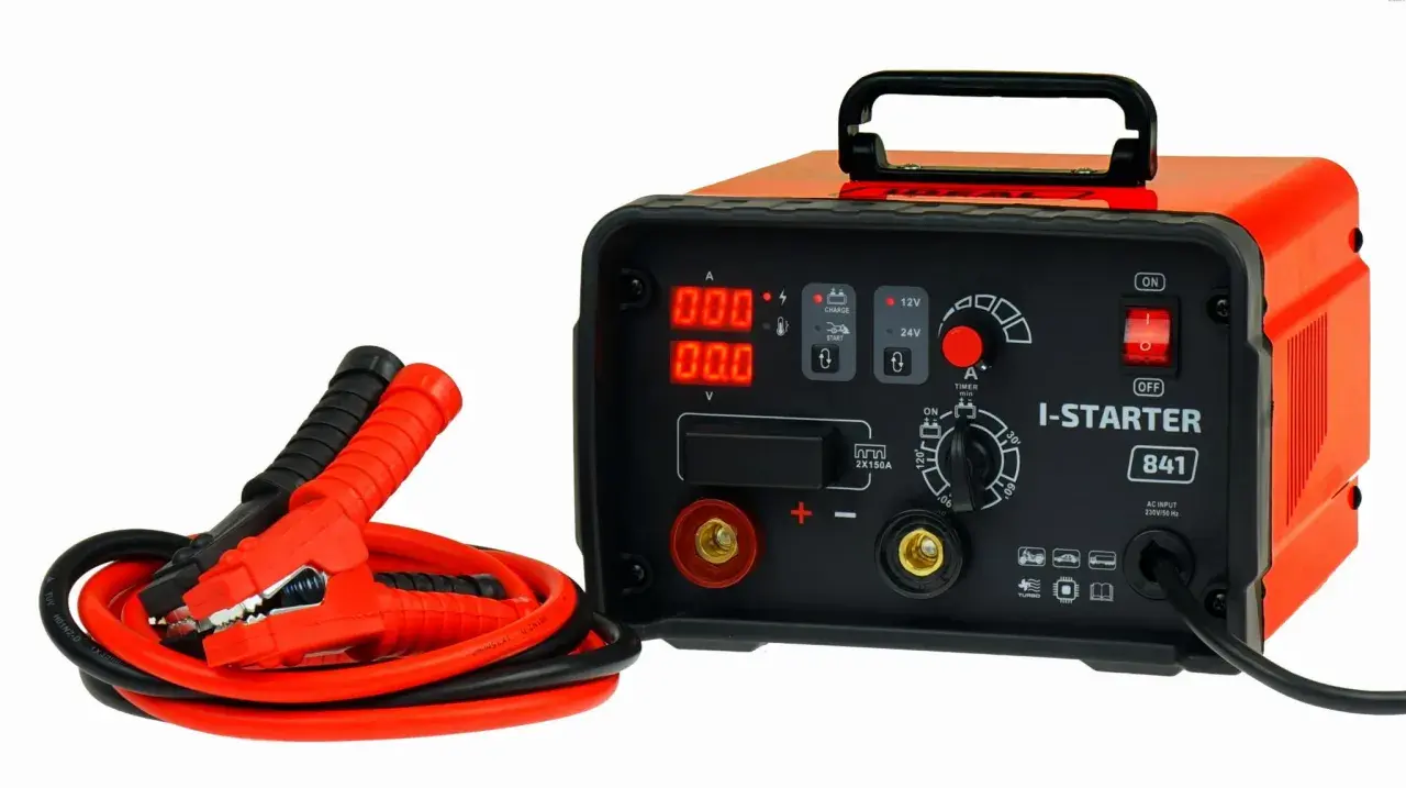 Pomarańczowy prostownik z kablami rozruchowymi. Zastanawiasz się, ile kosztuje dobry prostownik? Ten model I-STARTER 841 to solidny wybór.