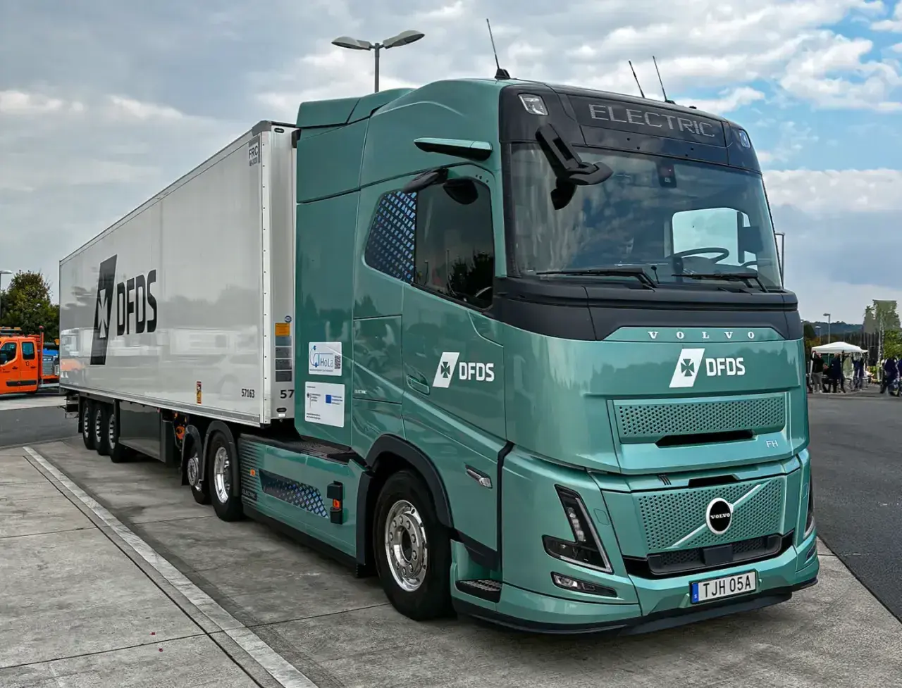 Zielony, elektryczny Volvo FH z naczepą DFDS. Zastanawiasz się, ile ton ma tir? Ten model jest gotowy na wyzwania.