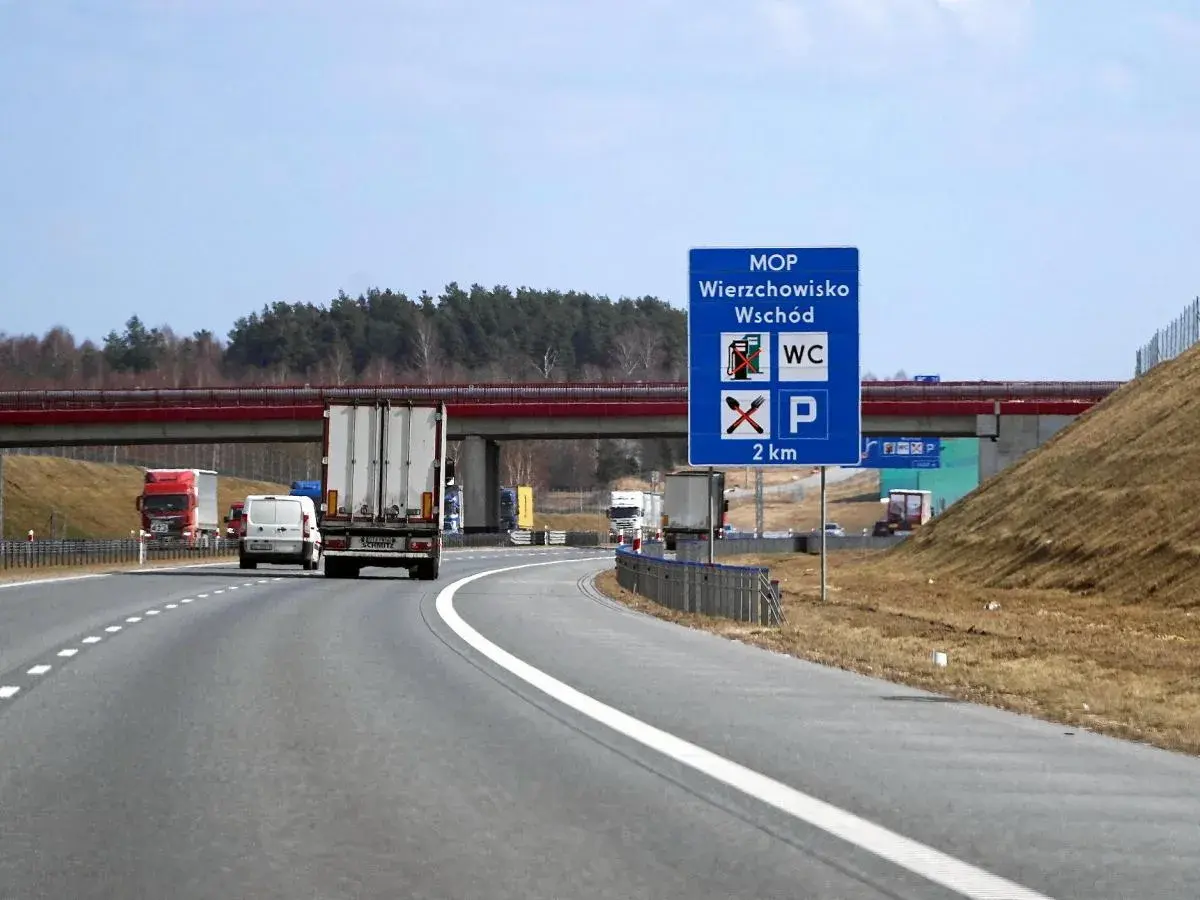 Znak MOP Wierzchowisko Wschód informuje o miejscu obsługi podróżnych z toaletą i parkingiem za 2 km.