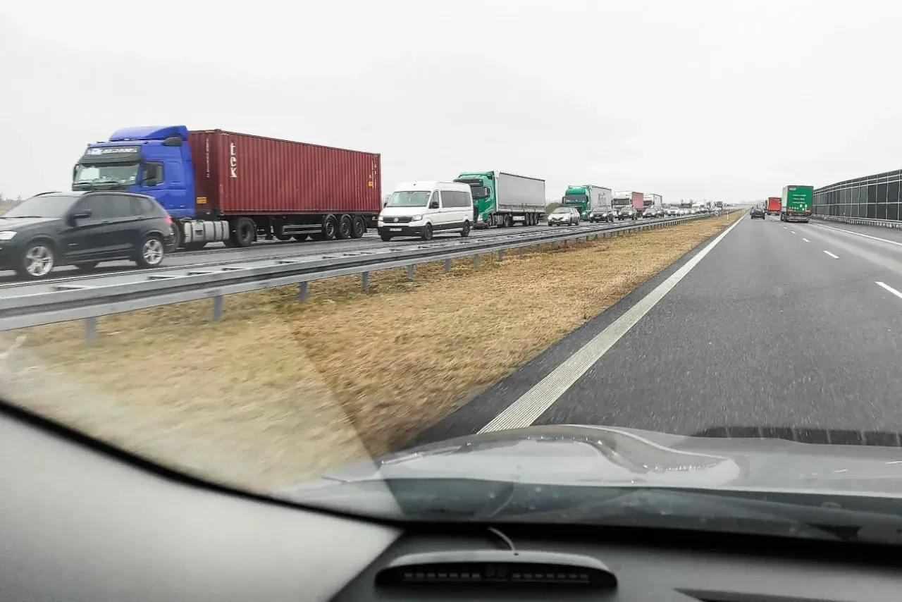 Korek na autostradzie. Zastanawiasz się, ile kosztuje autostrada z Warszawy do Berlina? Długi sznur ciężarówek i samochodów.