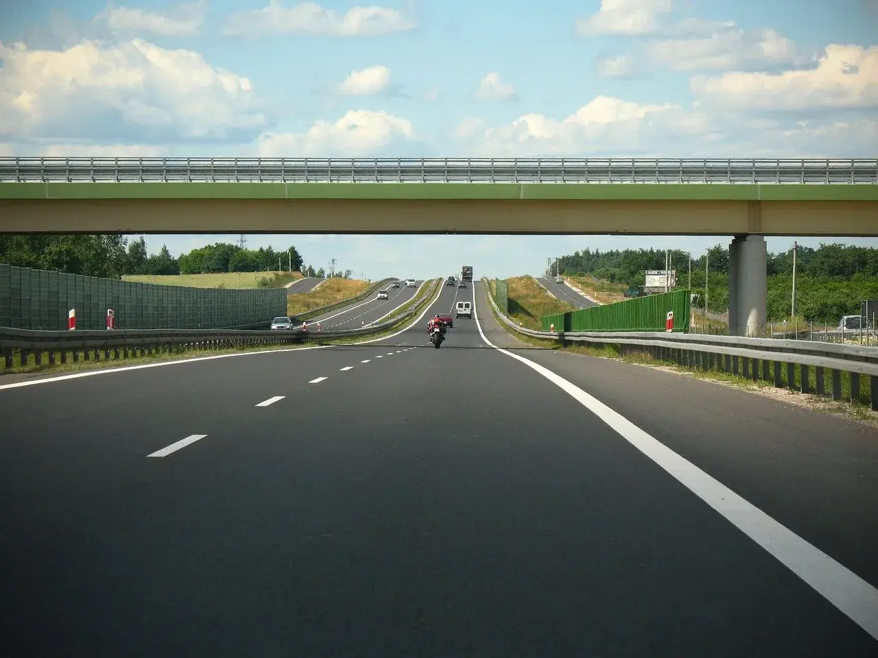 Autostrada w Niemczech, pod wiaduktem, z ruchem samochodowym. Zastanawiasz się, ile kosztuje km autostrady w Niemczech?