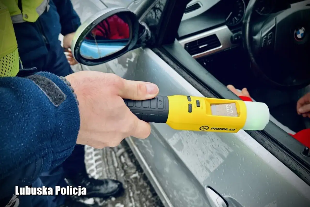 Policjant z Lubuskiej Policji używa alkomatu, by sprawdzić, ile jest dozwolone alkoholu w wydychanym powietrzu. Wynik 0.00.