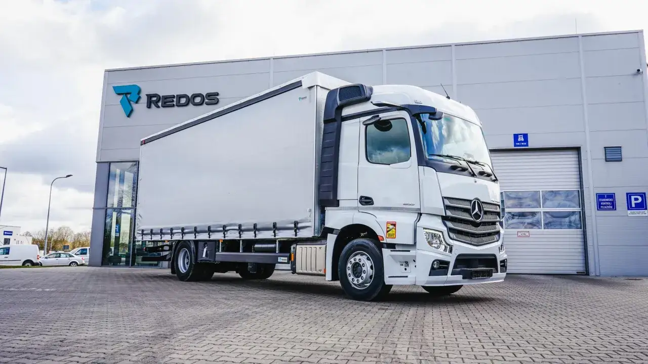Biały Mercedes-Benz Actros z naczepą, gotowy do załadunku. Zastanawiasz się, ile ton wchodzi na tira? Ten model może przewieźć nawet 24 tony!
