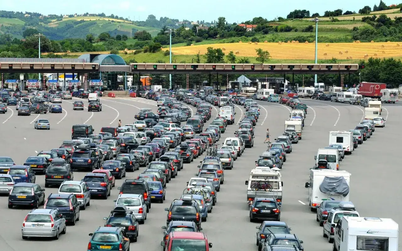 Korki na autostradzie we Francji. Długie kolejki samochodów i kamperów przed punktami poboru opłat.