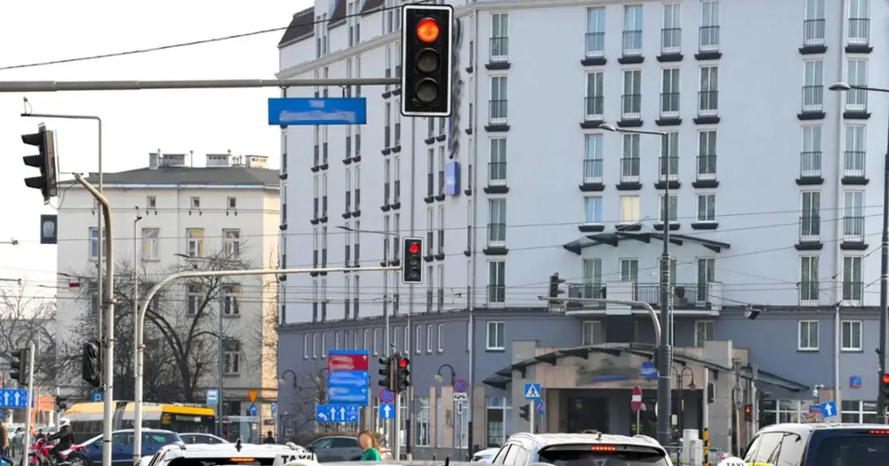 Czerwone światła na skrzyżowaniu w Warszawie. Ruch uliczny, budynki, sygnalizacja świetlna.